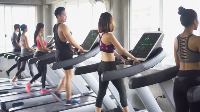group of young people running on treadmills in sport gym .fitness woman runner on running machine . workout . man .  rear back view . training . exercise .