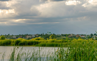sunset sky over the river, in the background a village with a Church