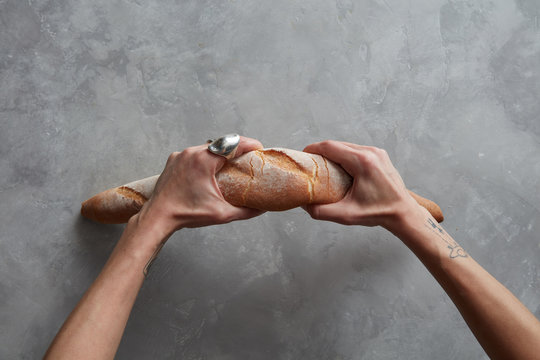 Hands holding loaf of bread