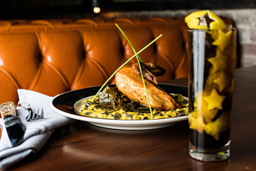 Chicken with corn and collard greens and a drink with star shaped garnish