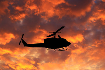 Fototapeta na wymiar silhouette the helicopter on sunset