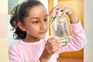 Young girl with a grasshopper in a jar