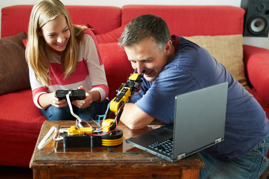 Girl learning about robot programming with her dad