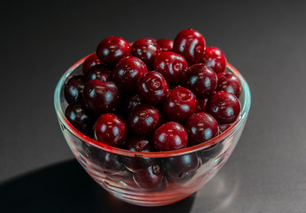 ripe red cherry in Cup on black background