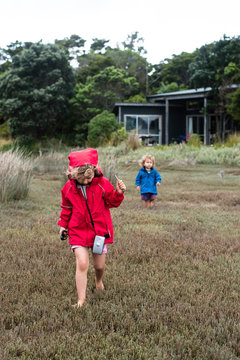 Sister and younger brother exploring an estuary, New Zealand.