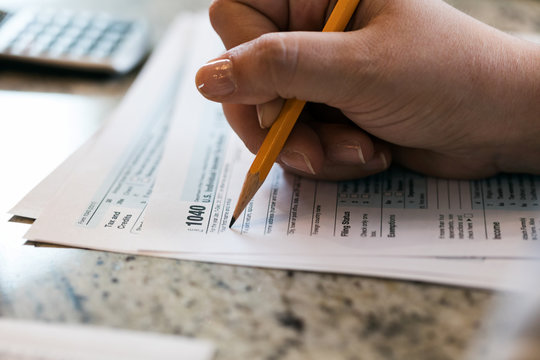 Taxes: Woman Filling Out 1040 Tax Form