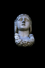 Fragment of ancient statue of the goddess of wisdom and victory Athena isolated on black background.