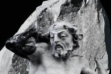Ancient statue of Sisyphus with stone. God Zeus punished Sisyphus: he had to roll very big stone to...