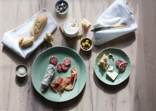A european inspired lunch of baguette, cheese, charcuterie, olives and anchovies.
