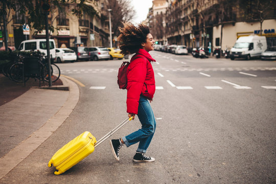 Young female traveller crossing the road