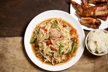 Spicy papaya salad,grilled chicken wing and sticky rice. Thai food (Som Tum)