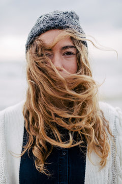 Portrait of a blonde woman on beach in winter.