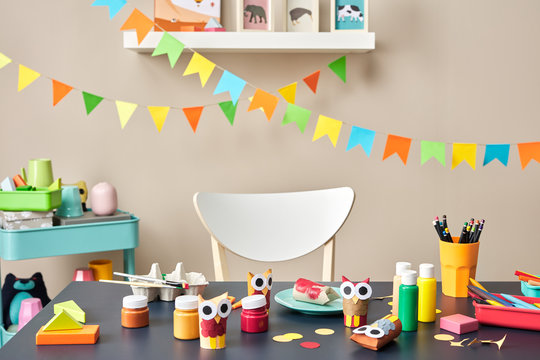 Desk of prechool child with colorful garlands with flags in back