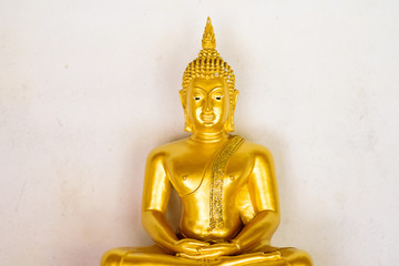 Meditation golden buddha statue on old white wall in the temple