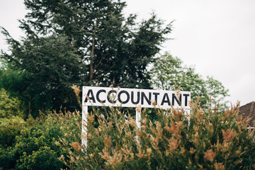 Accountant sign in bushes