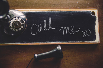 vintage candlestick telephone with personalized note on chalkboard