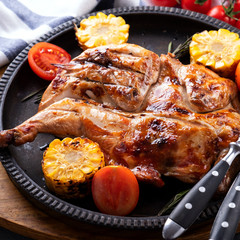 Roasted whole  chicken  with corn and tomatoes. Closeup