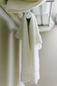white bath towels hanging from a rack