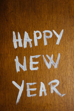 Happy new year"" lettering on wooden board