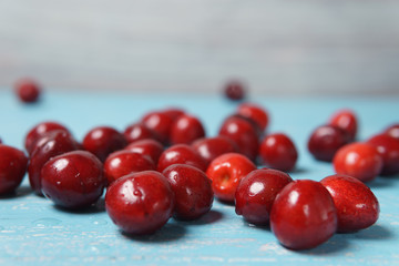 Red sweet cherry scattered on a turquoise wooden table