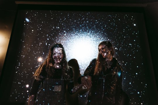 Young couple with stars and galaxies projected on them