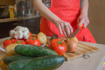 woman hands cutting vegetables on kitchen blackboard. Healthy food. Woman preparing vegetables, cooking healthy meal in the kitchen