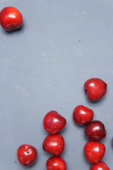 Red sweet cherry scattered on a gray background