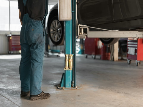 Crop technician lifting car up with equipment