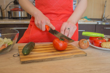 Young woman cooking healthy meal in the kitchen. Cooking healthy food. Woman in kitchen preparing vegetables