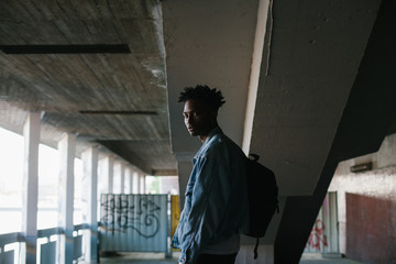 Young man in a denim jacket posing looking at camera