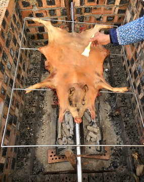 Fresh and delicious roast suckling pig, baked in a homemade red brick charcoal stove