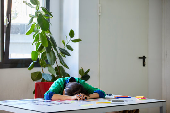 Exhausted Executive Lying With Head Down On Table