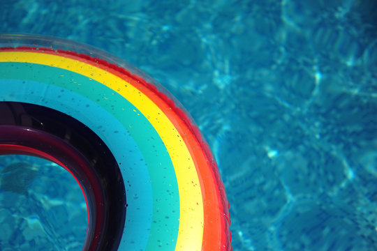 a rainbow pool float lies in a swimming pool