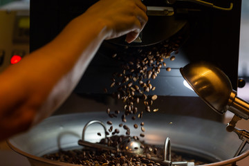 A coffee roaster with beans falling out into the cooling pan