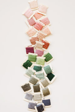 pretty colors of embroidery thread down the middle of a white background