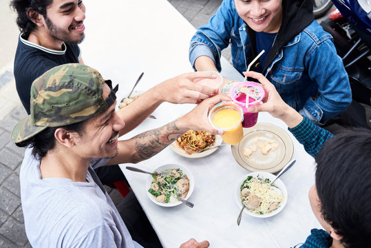 Best friends celebrating eating street food and healthy fresh juice.