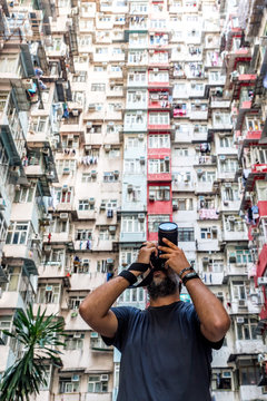 Photographer taking pictures of residencial buildings facades in Hong Kong