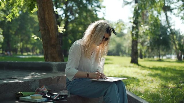 Female Artist Preparing a Sketch for Future Picture in Slow Motion. Professional Painter at Work in a City Park in Sunny Summer Day. Creativity Inspiration Expression Concept