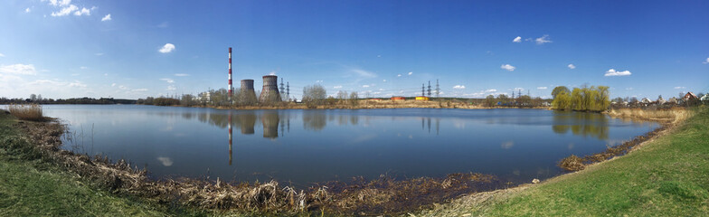 Fototapeta na wymiar Panorama of lake with pipes of power station on shore