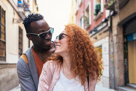 Multiethnic young couple having romantic moments together in the street