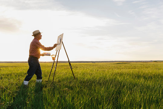 Man Painting in a Field with Watercolors