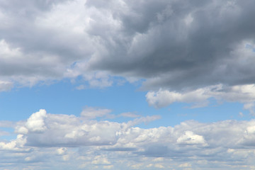 Blue sky texture background with white fluffy clouds. Horizontal, nobody, place for text. The concept of nature and meteorology.