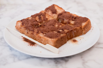 Focus on toast, sprinkle with delicious Ovaltine. On the marble table
