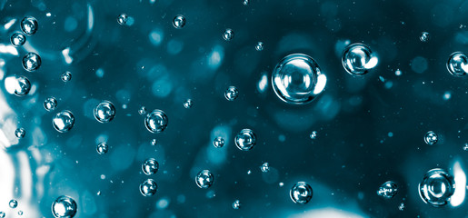 Bubbles of air on the smooth surface of blue water as an abstract background