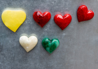 yellow red white and green stone heart on top a wall