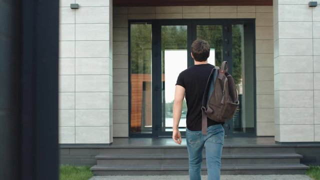 Casual Man Entering Modern Office With Backpack. Modern Man Going Up Stairs