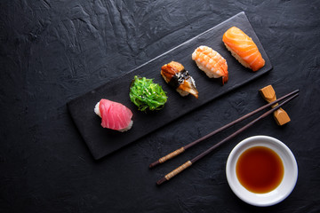 Set of sushi and maki on dark stone table. Top view with copy space