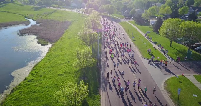 Aerial, crowd of people run marathon in park