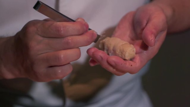 Hands of Sushi Restaurant Chef Cleaning Prepared Sushi from Small Fish Bones. Close Up Slowmotion