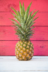 Holiday pineapple on red wooden background